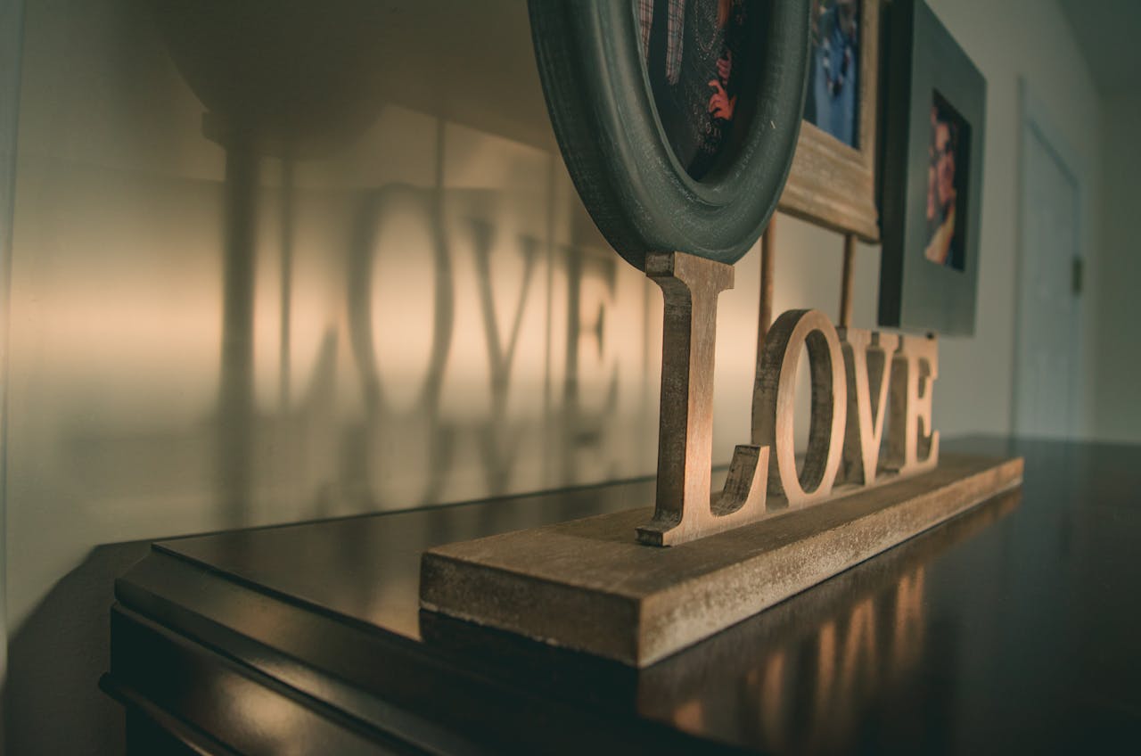 gallery-6 Stylish home decor featuring a wooden love sign with its reflection on a wall.