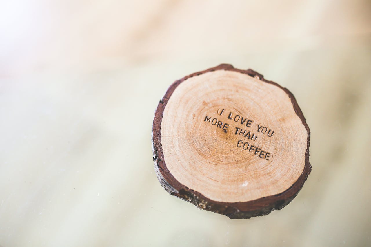 services-01 Rustic wooden coaster with the quote 'I love you more than coffee' engraved on it.